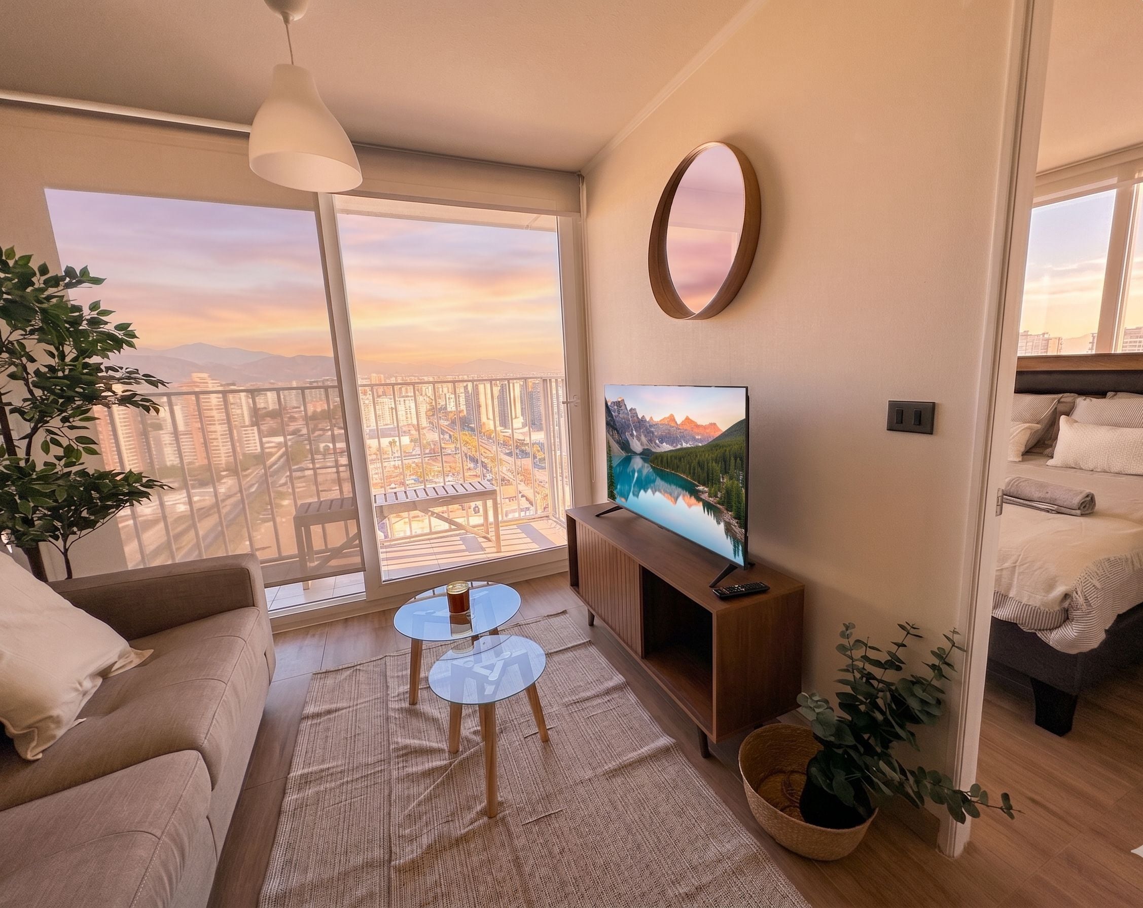 Ein modernes Wohnzimmer mit Balkon, einem Flachbildfernseher, einer Couch, einem Couchtisch und einem Bett.