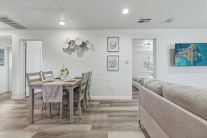 Uma sala de estar moderna com área de jantar, sofá e globo fixado na parede.