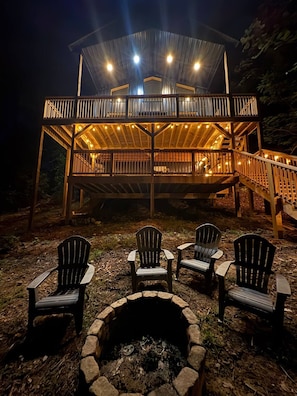 A multi-level wooden deck with outdoor seating and a fire pit. - Chasin Turkeys | Lakefront Cabin w/ Hot Tub, Arcade Game & Fire Pit (Campton)