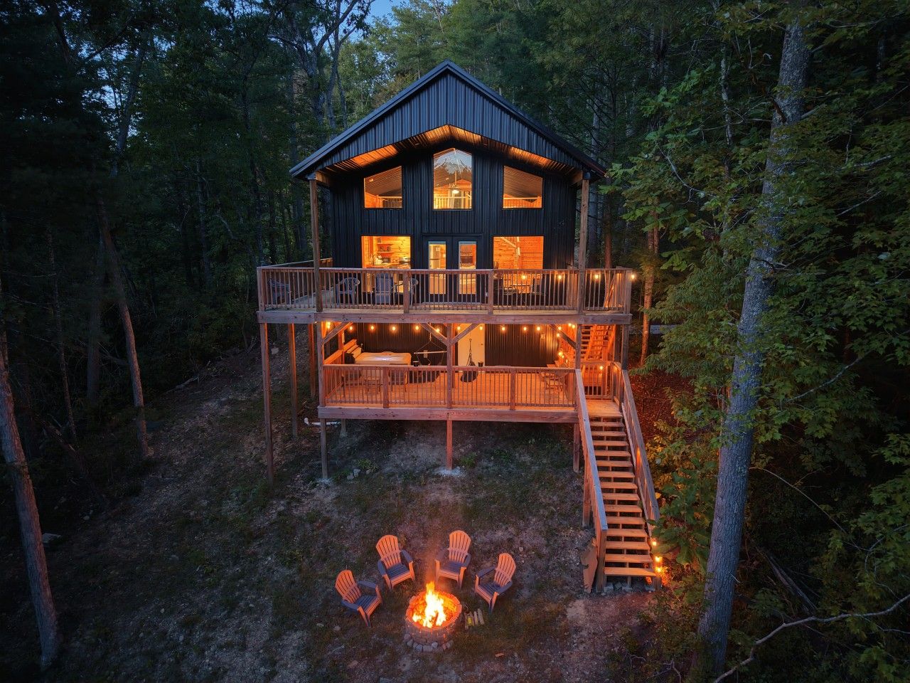 A cabin with a deck, a fire pit, and outdoor seating.