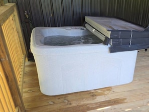 A hot tub with a cover partially open, placed on a wooden deck. - Chasin Turkeys | Lakefront Cabin w/ Hot Tub, Arcade Game & Fire Pit (Campton)