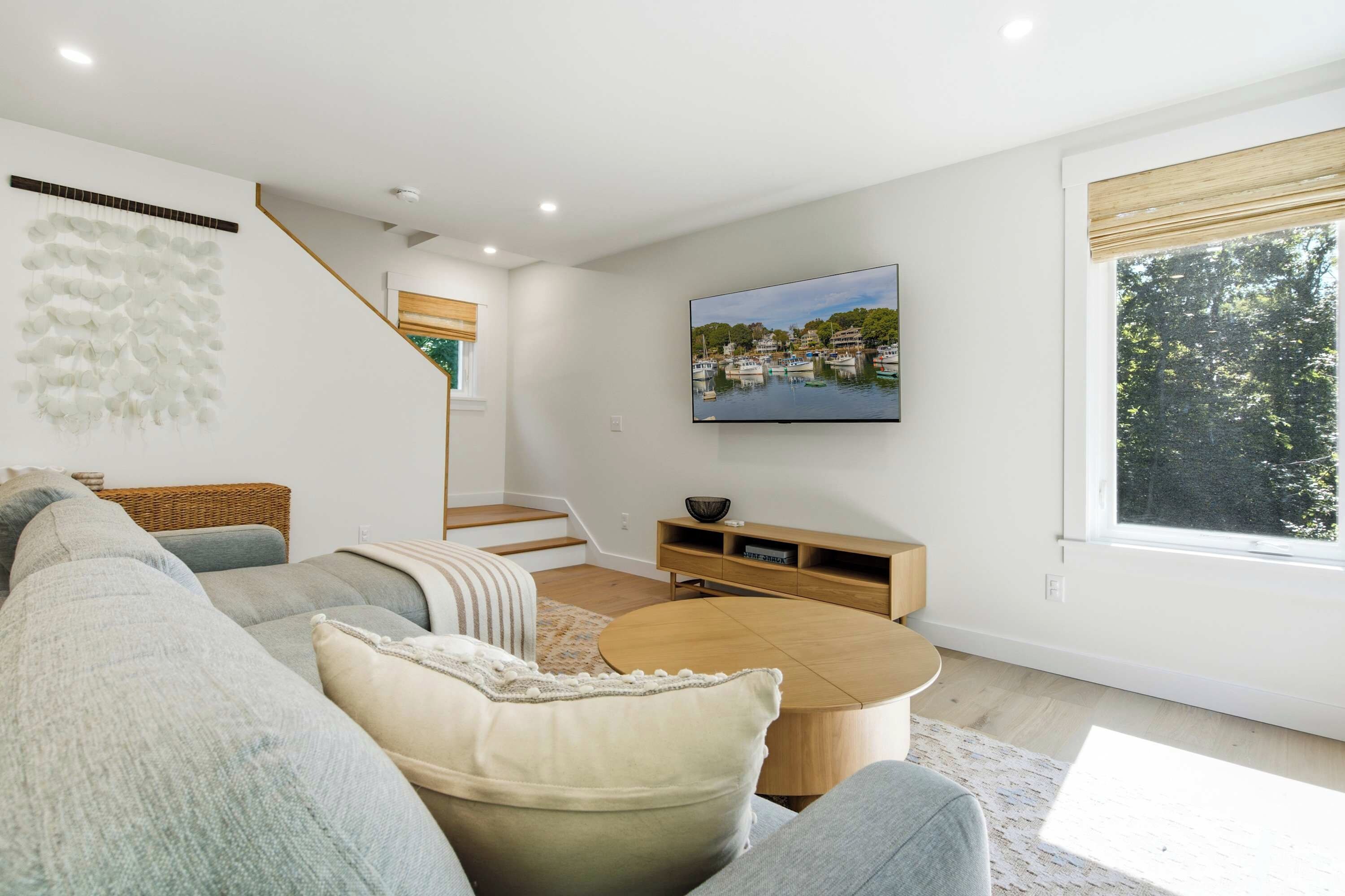 A modern living room with a sofa, coffee table, and a TV mounted on the wall.