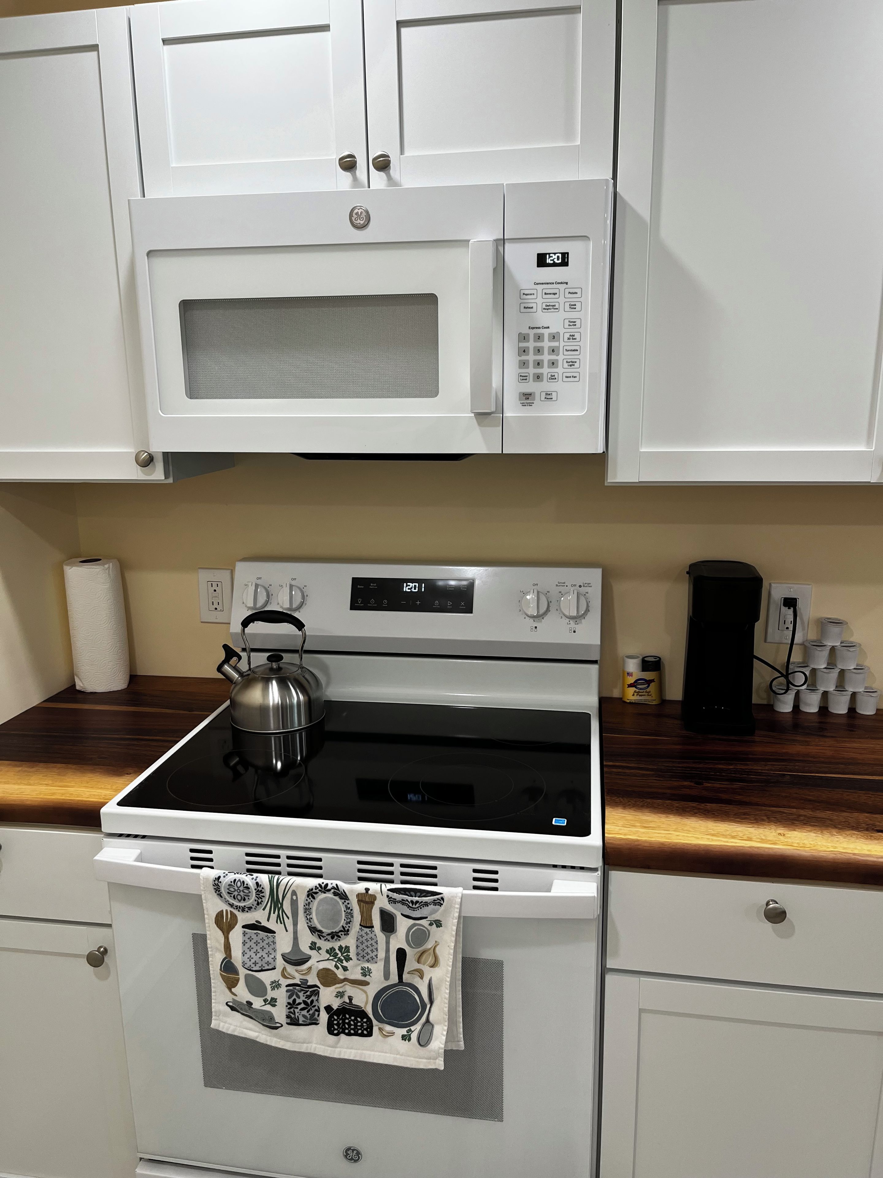 A kitchen with a microwave, stove, and oven.