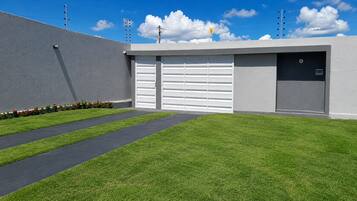 A modern building with a garage door, a paved driveway, and a well-maintained lawn.