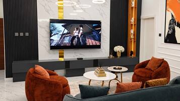 Een moderne woonkamer met een flatscreen televisie, twee banken en een salontafel.