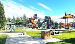 A playground with various play structures, a picnic area, and a bench. - Gated bungalow · work desks · fast WiFi · parking (Los Angeles)