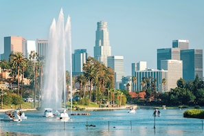 A city skyline with modern buildings, a large fountain, and boats on a lake. - Gated bungalow · work desks · fast WiFi · parking (Los Angeles)