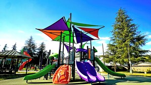 Ein Spielplatz mit mehreren Rutschen und einer Kletterkonstruktion.