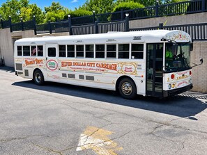 Un autobus à l’allure rétro, arborant l’inscription « Silver Dollar City Carriage », est garé dans une rue.