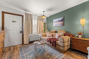 A cozy living room with a sofa, a coffee table, a lamp, and a painting on the wall. - Gold Rush-less then a half mile to Silver Dollar City! (Branson)