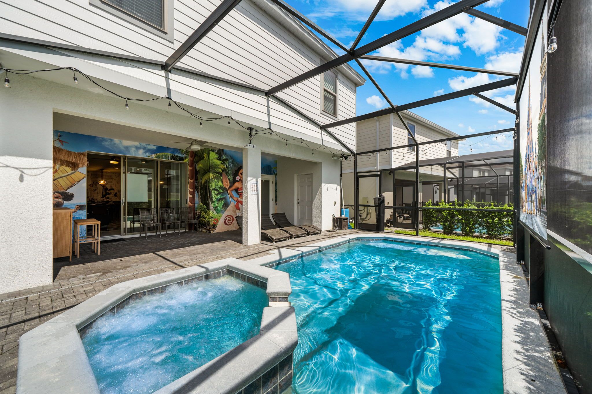 A swimming pool with a hot tub, outdoor seating, and a covered patio area.