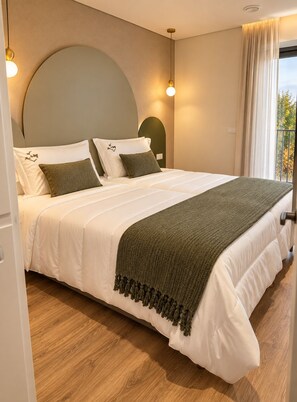 A bedroom with a large bed, two bedside lamps, a window with curtains, and a view of trees. - House Park (Gandra)