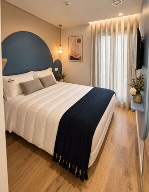 A bedroom with a bed, a headboard, a bedside table, a lamp, a wall-mounted TV, a window with curtains, and a wall-mounted shelf with a vase. - House Park (Gandra)
