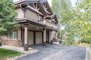 A two-story house with a covered garage and a stone foundation. - Ground Level | On Bus Route | 3 SmartTVs | Updated (Steamboat Springs)