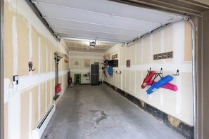 A garage with a concrete floor, a ceiling-mounted projector, and various tools and equipment on the walls. - Ground Level | On Bus Route | 3 SmartTVs | Updated (Steamboat Springs)