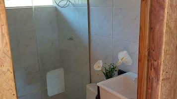 A bathroom with a toilet, sink, and shower area.