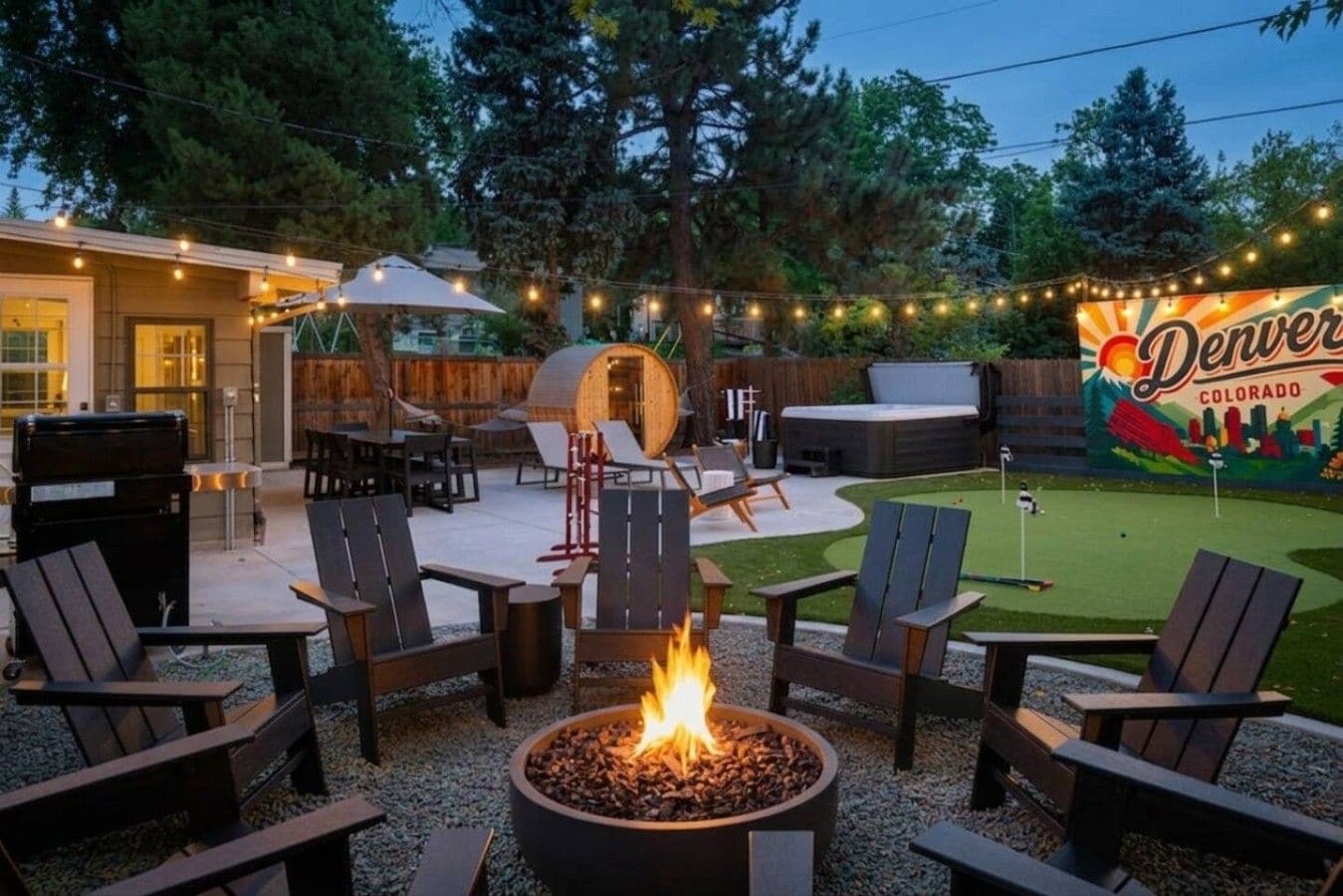 An outdoor patio area with a fire pit, seating, and a hot tub.