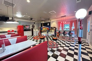Een klassiek diner met zwart-witte vloertegels, rode banken en een jukebox.