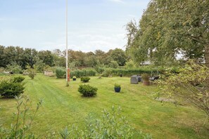 A well-maintained garden with various shrubs and a swing set. - Cozy and spacious house (Vrå)