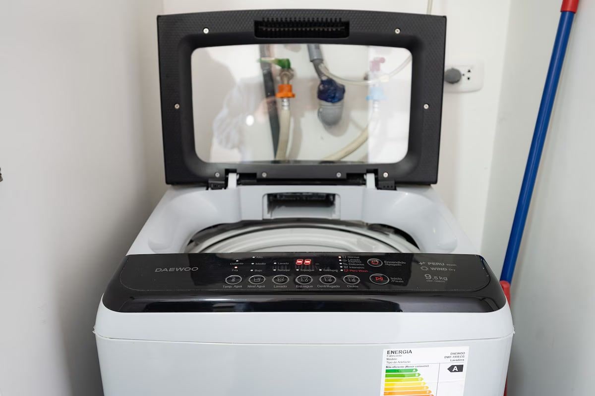 A front view of a washing machine with a digital control panel and a transparent door.