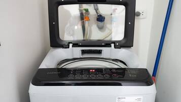 A front view of a washing machine with a digital control panel and a transparent door.