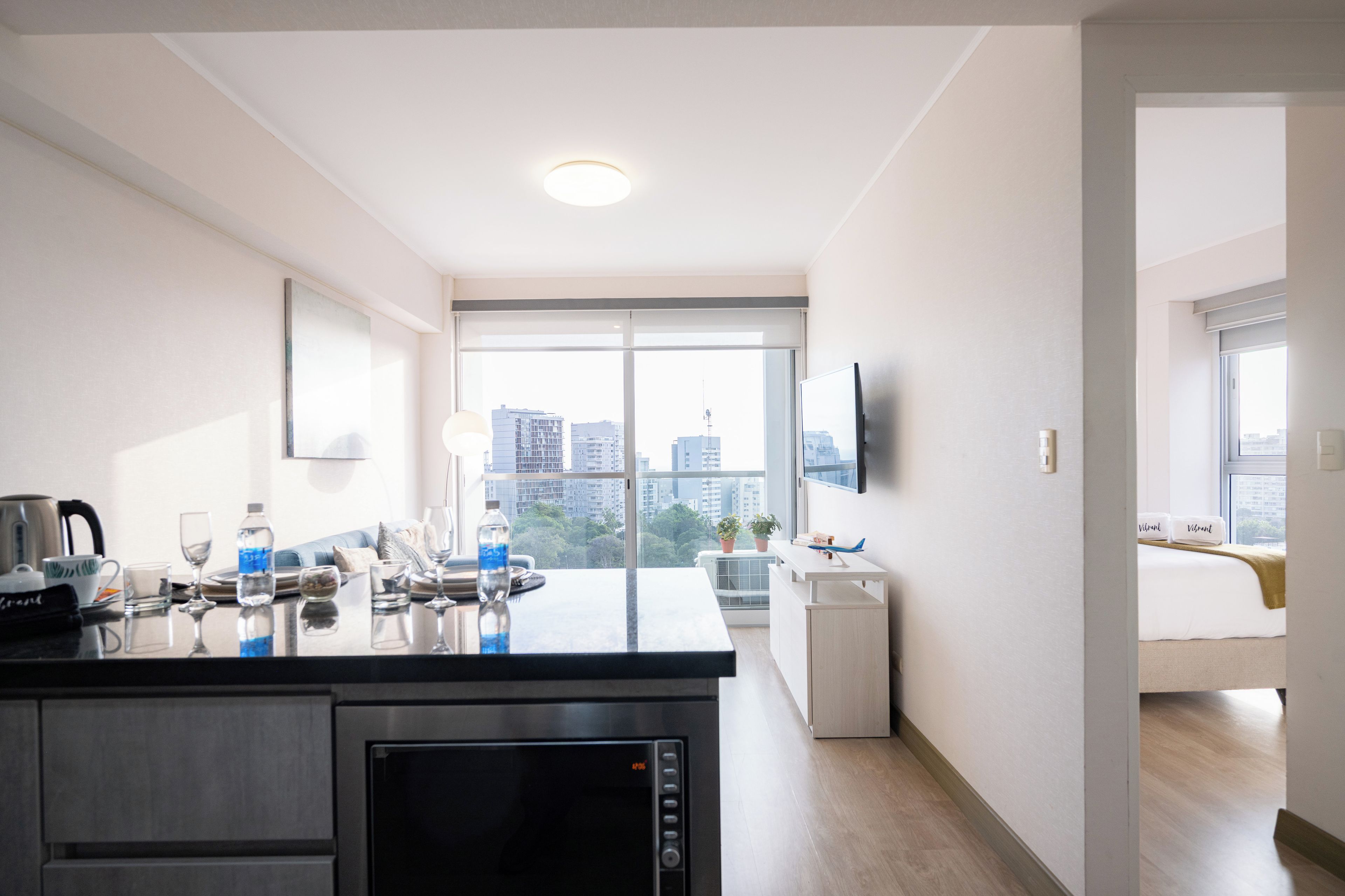 A modern kitchen with a built-in microwave, a coffee maker, and a water dispenser.