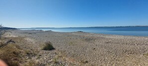 A pebbly beach with a clear view of the water and distant land. - Lovely holiday oasis on scenic Thyholm (Thyholm)
