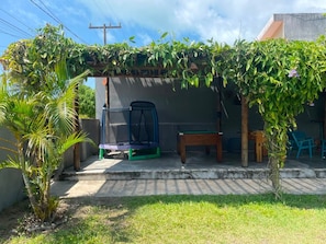 A covered outdoor area with a trampoline, a table, and a bench. - Porto de Galinhas - Serrambi - Loctemp (Ipojuca)