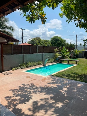 A swimming pool with a tiled deck, surrounded by a low wall and greenery. - Porto de Galinhas - Serrambi - Loctemp (Ipojuca)