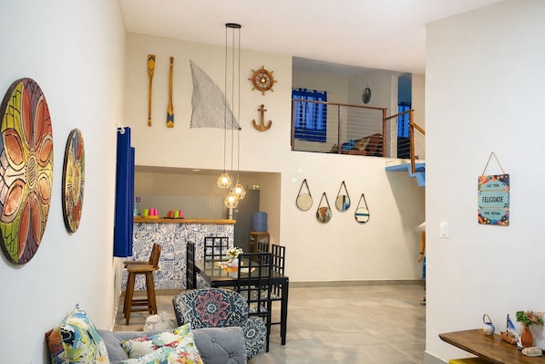 A living room with a dining area, a kitchen, and a staircase.