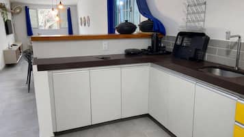 A modern kitchen with white cabinets, a brown countertop, and a built-in sink.