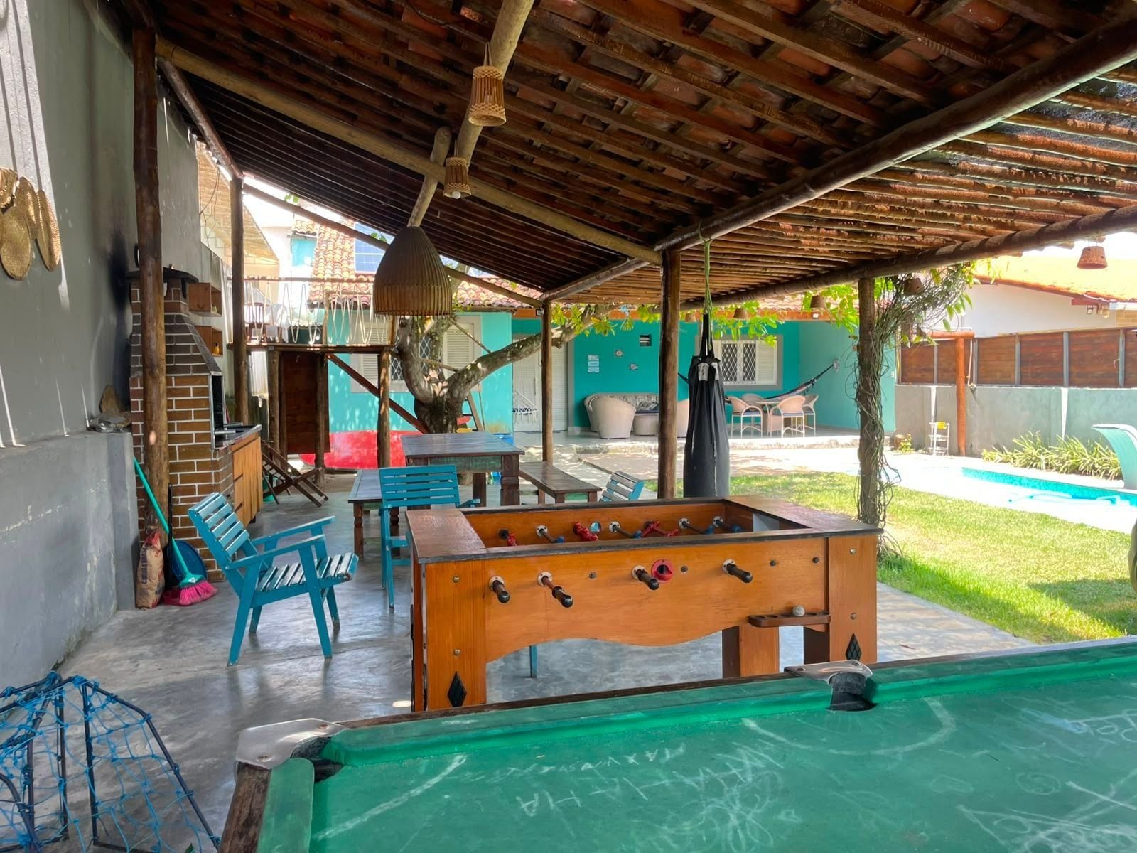 An outdoor recreational area with a foosball table, seating, and a pool.