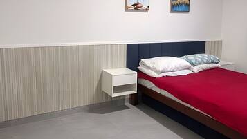 Une chambre à coucher comprenant un lit, une table de chevet et une œuvre d’art accrochée au mur.