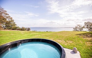 Ein Whirlpool in einer grünen Umgebung mit Blick auf das Meer.