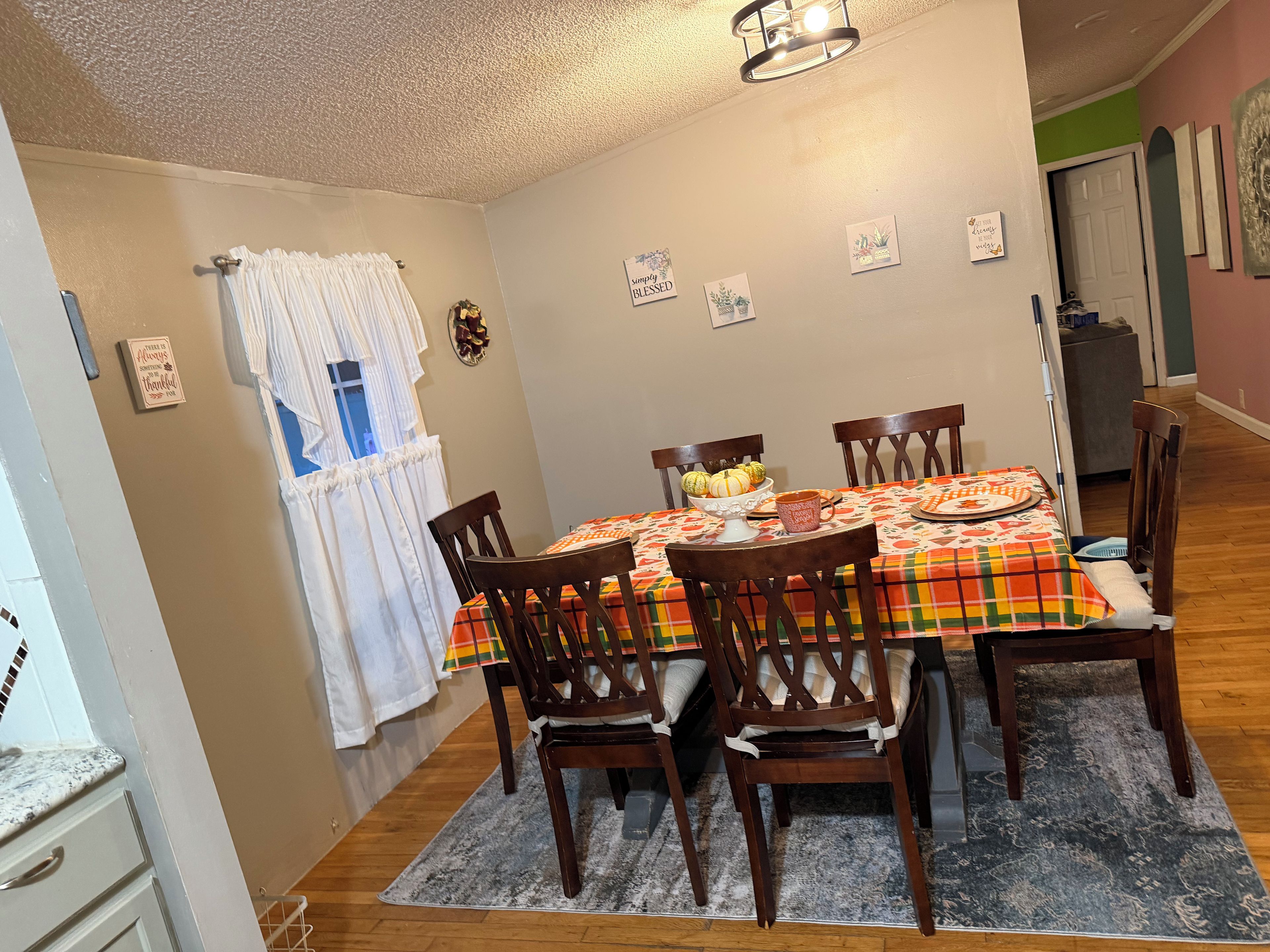 Comedor con una mesa dispuesta para cuatro personas, rodeada de sillas de madera.