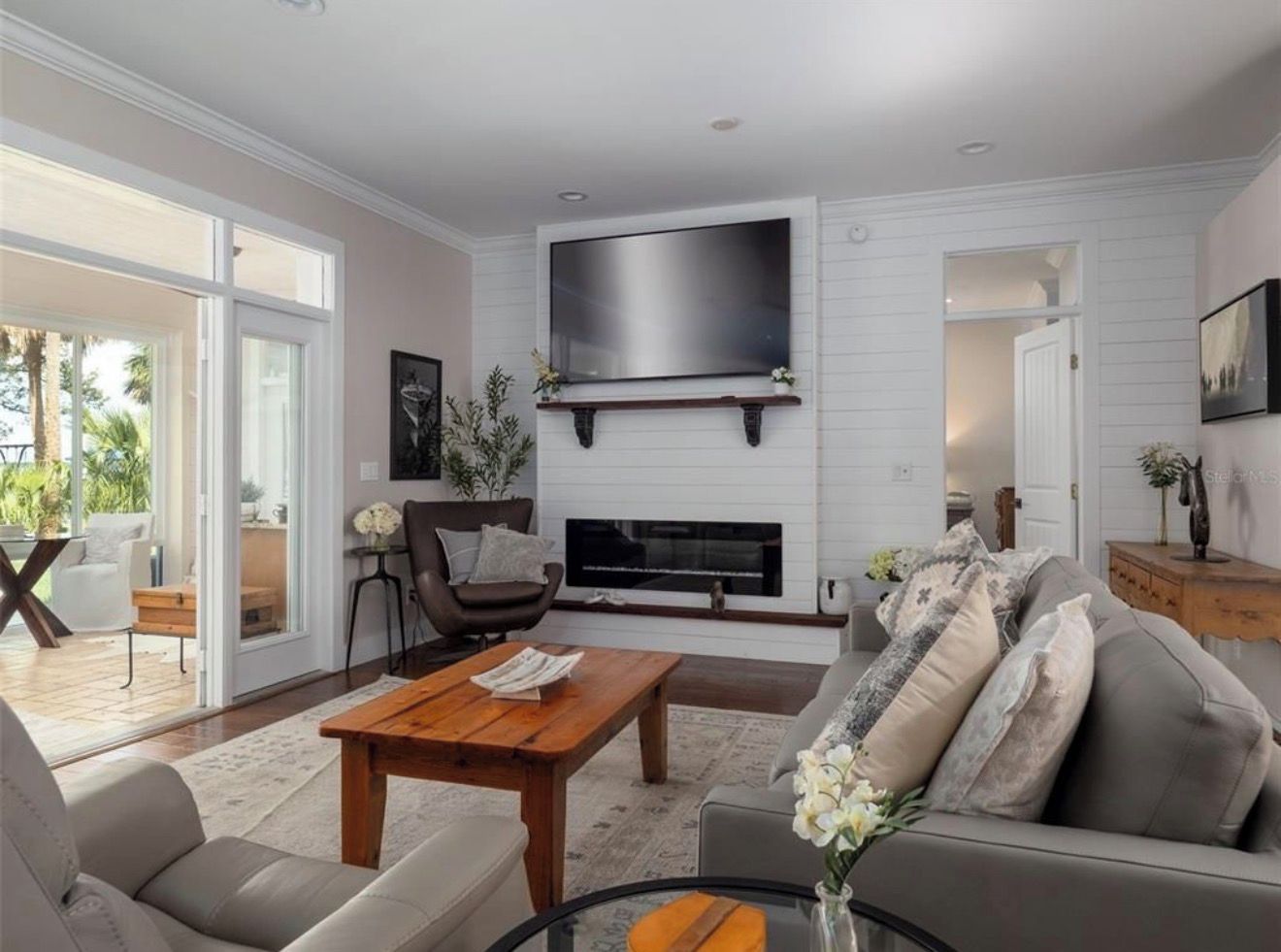 A modern living room with a flat-screen TV, fireplace, and comfortable seating.