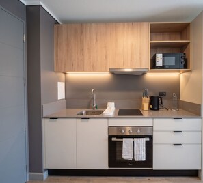 Eine moderne Küche mit eingebautem Backofen, einer Mikrowelle und einem Spülbecken.