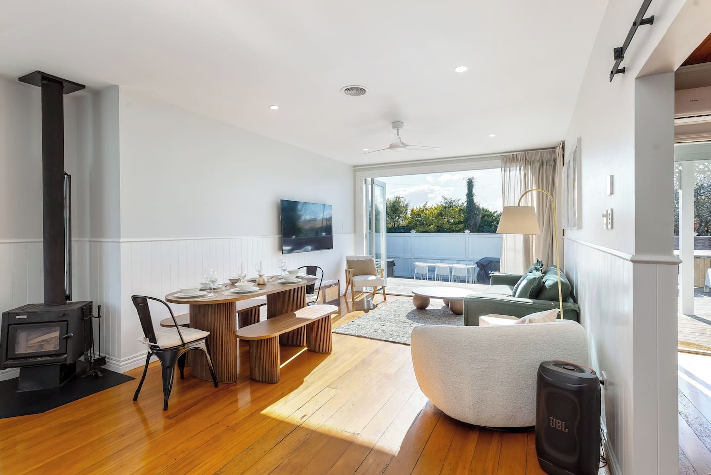 A modern living room with a fireplace, dining area, and a view of the outdoors.