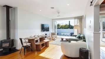 A modern living room with a fireplace, dining area, and a view of the outdoors.