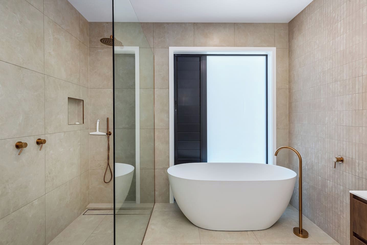 Un baño moderno con una bañera independiente, ducha con mampara de vidrio y un diseño minimalista.