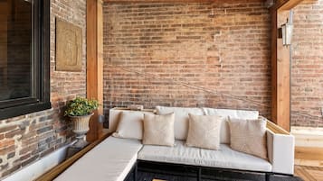 A cozy seating area with a sofa, cushions, a potted plant, and a wooden coffee table.