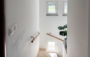 A staircase with a handrail, a light switch, and a potted plant. - Cozy apartment in Valbandon with swimming pool (Valbandon)