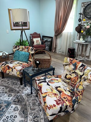 A living room with a sofa, armchair, and a small table. There is a lamp, a framed picture, and a potted plant. - Spacious 4-bedroom house in quaint rural Barbourville surrounded by the mountain (Barbourville)