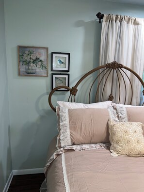 A bedroom with a bed, framed artwork, and a curtain. - Spacious 4-bedroom house in quaint rural Barbourville surrounded by the mountain (Barbourville)