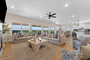 A spacious living area with a large sofa set, a coffee table, and a dining area with chairs. - Table Rock Lake Views | 10BR Lodge Sleeps 30 (Kimberling City)