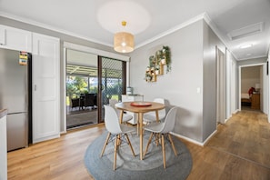 A dining area with a round table, chairs, and a rug. - Hazel Haven—Beach Lifestyle with Spacious Garden (Goolwa Beach)