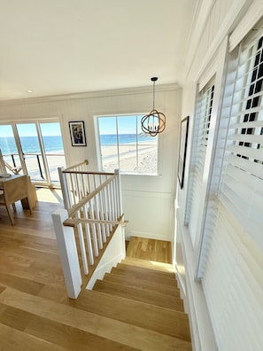 A staircase leading to a balcony with a view of the beach.