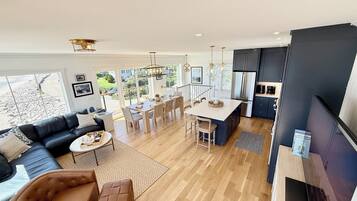 A modern living space with a dining area, kitchen, and seating area.