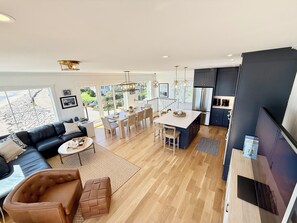 A modern living space with a dining area, kitchen, and seating area.