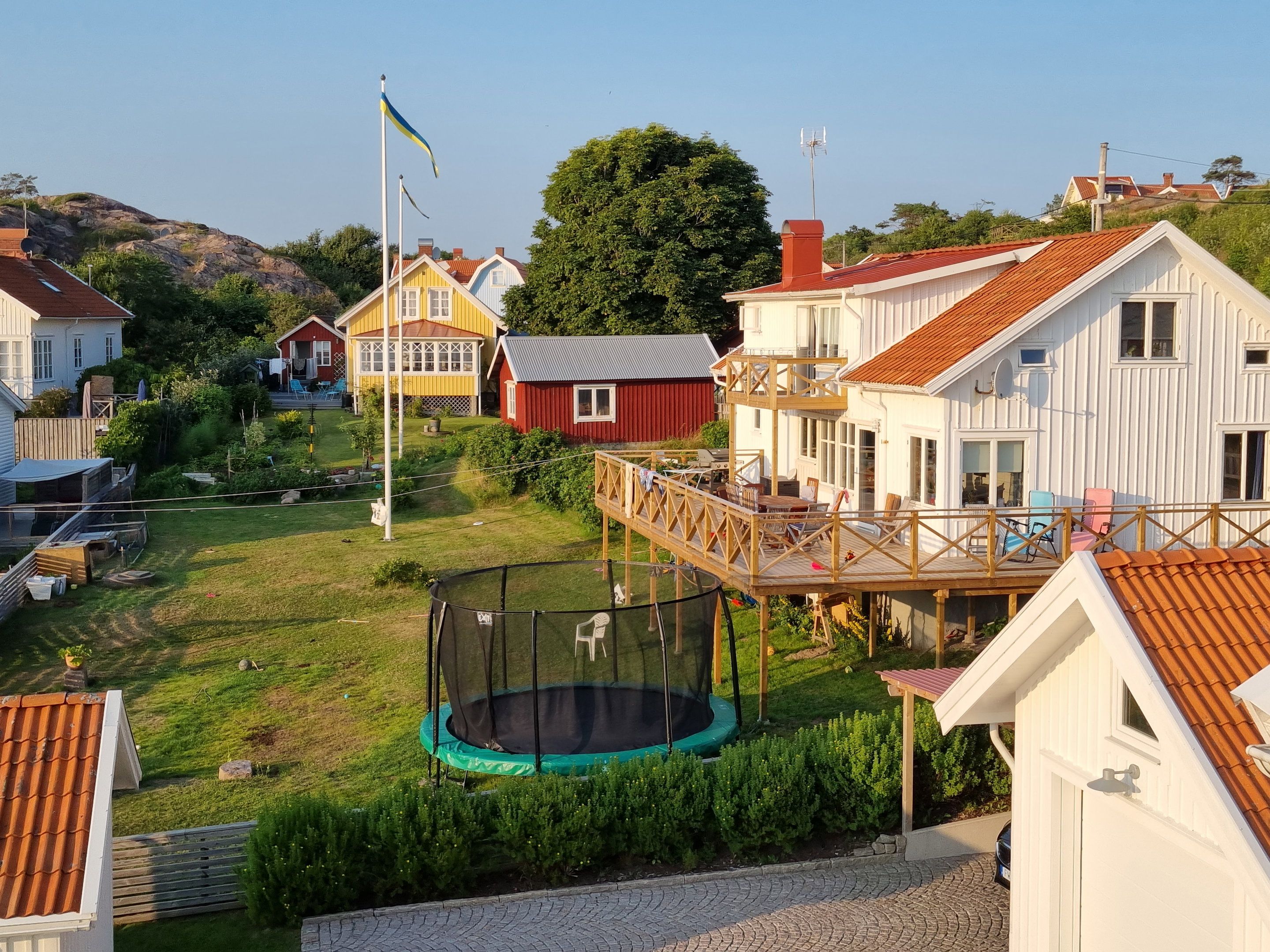 Ett bostadsområde med hus, en studsmatta och en flagga.